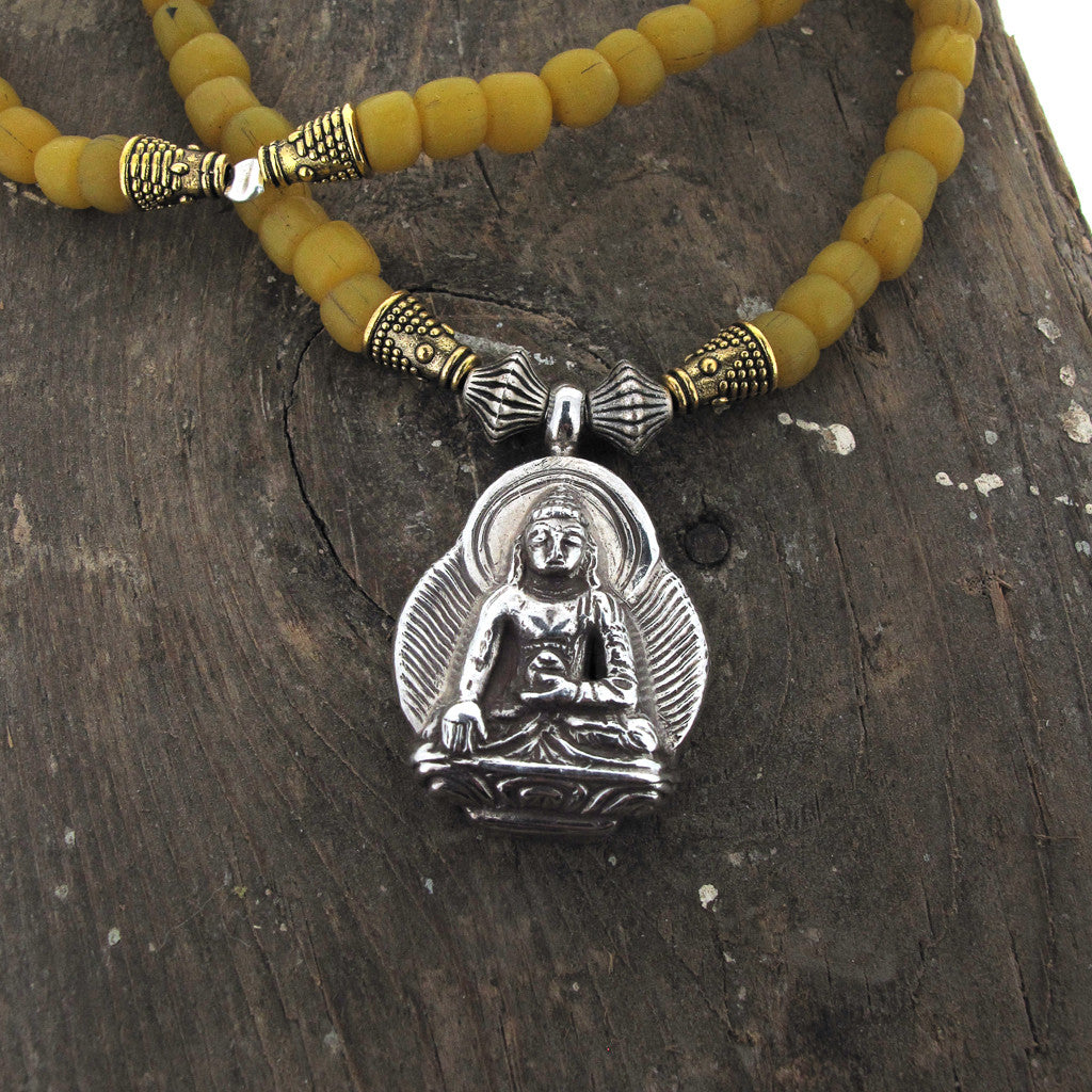 Tibetan seated silver Buddha on glass bead necklace