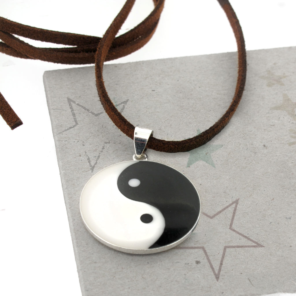 Ying and Yang sterling silver pendant, on faux brown suede